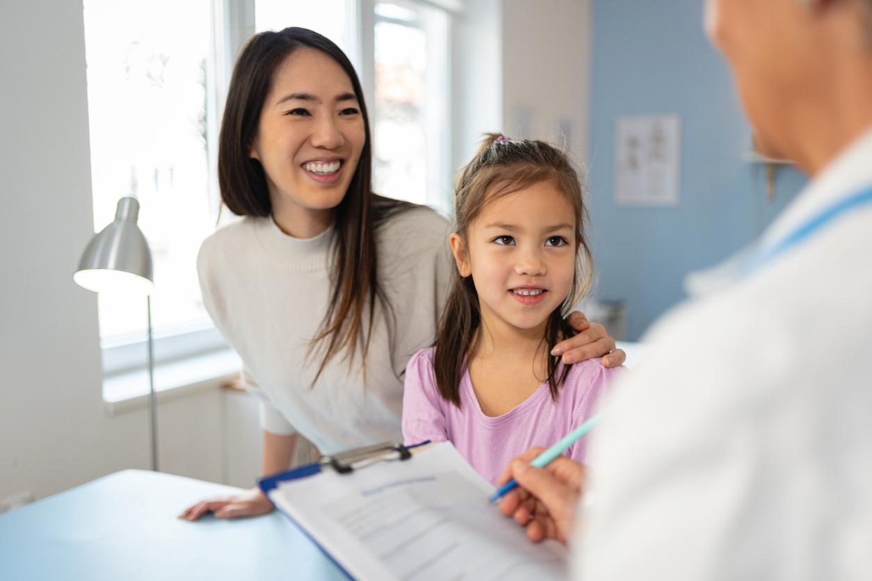 Japanese girl at the senior female Caucasian pediatrician with her mother, for an annual medical check-up.