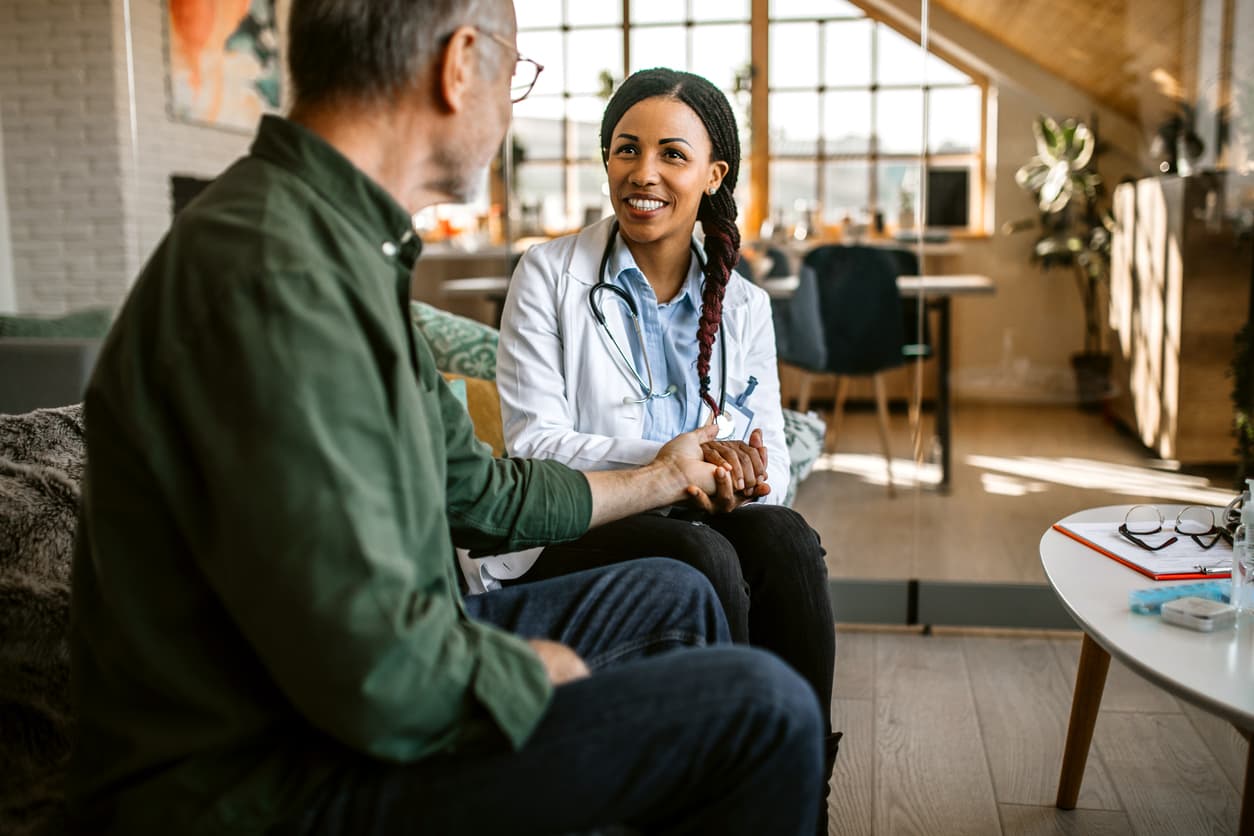 Female doctor providing compassionate home healthcare visit and consultation with senior patient at home