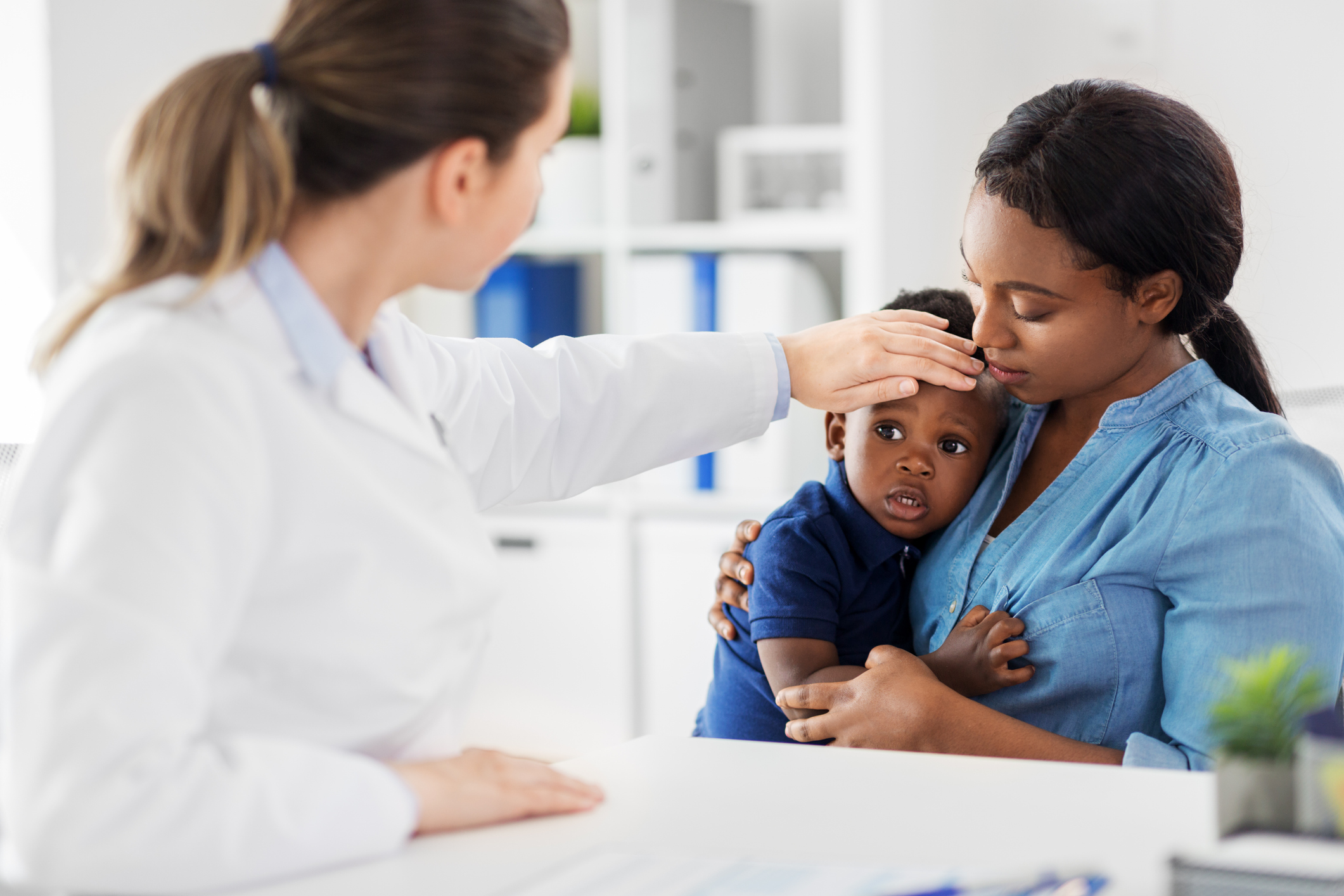 mother with sick baby son and doctor at clinic