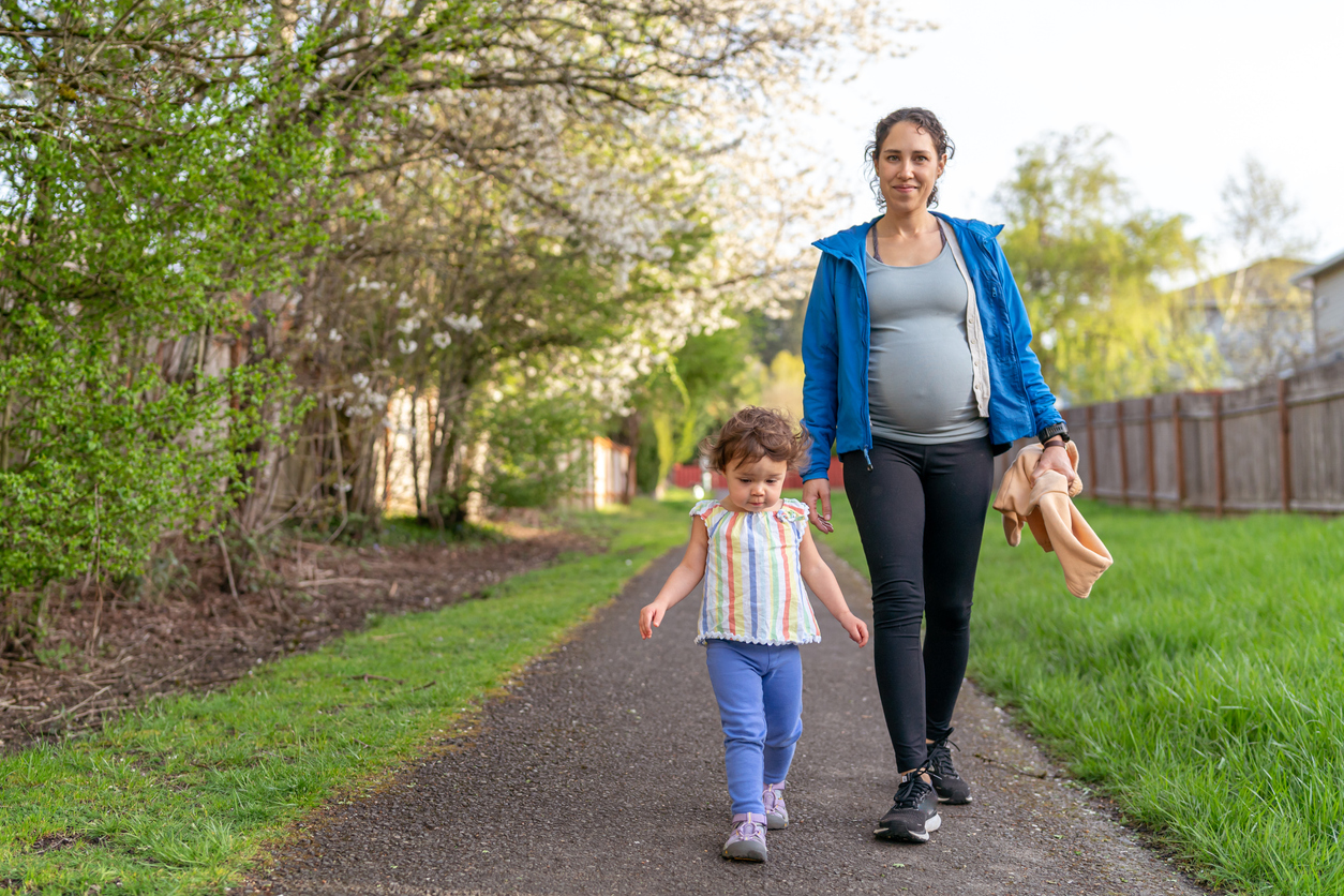 Pregnant woman on a walk with her toddler daughter