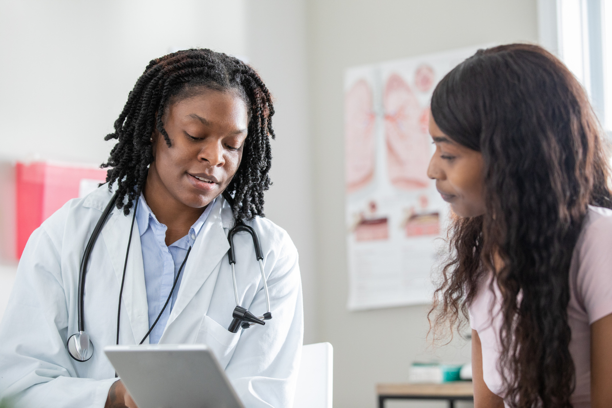 Healthcare professional uses digital tablet to help patient understand options during appointment in local clinic