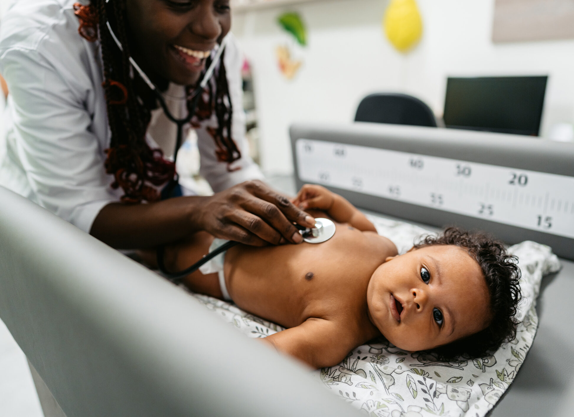 Close-up of a female pediatrician auscultating a mixed race newborn baby in the hospital.