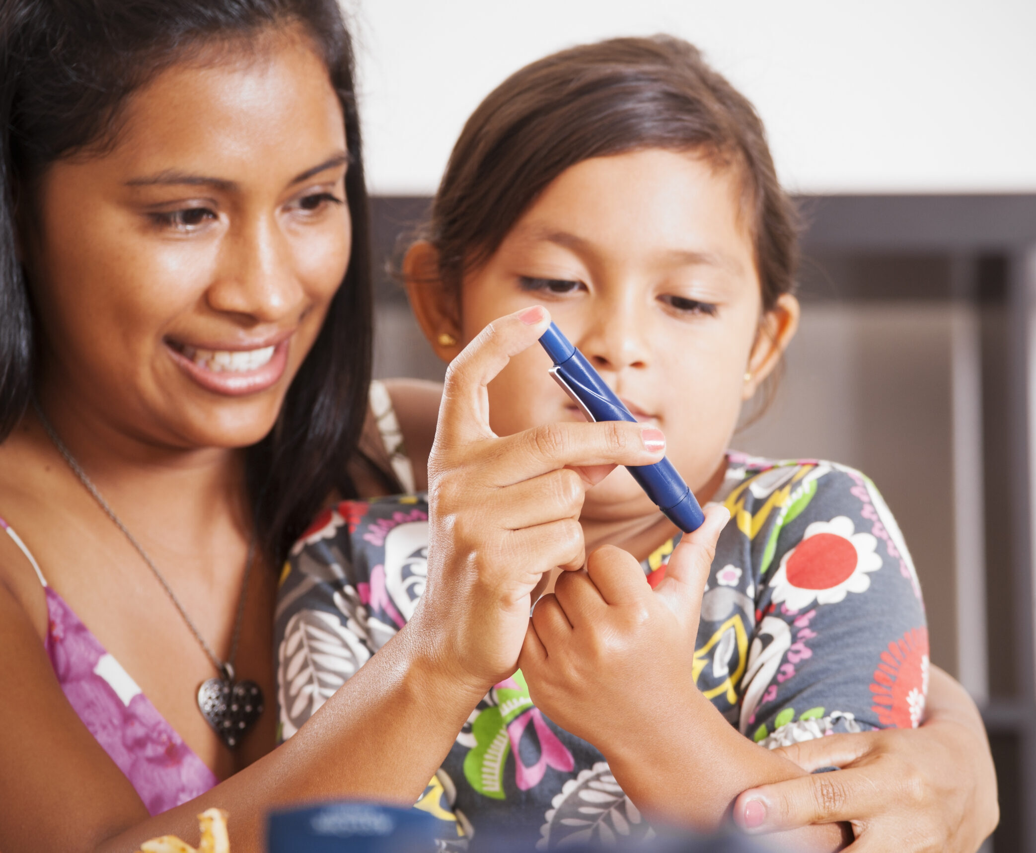 Nother helping her diabetic child monitor her blood sugar.