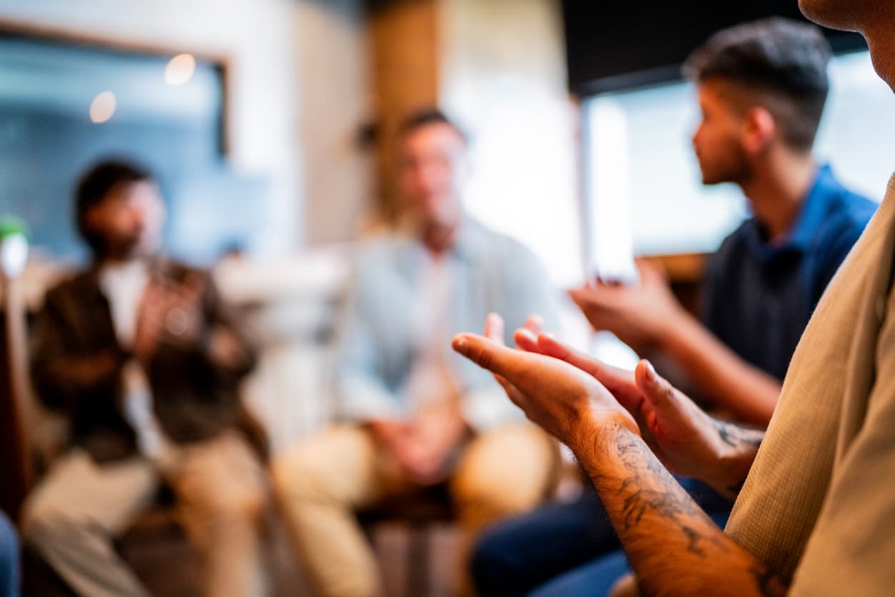 Individuals participating in a behavioral health group therapy session focused on emotional support and recovery.