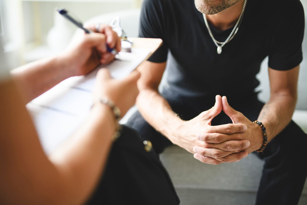 Man meeting with a mental health professional during a private counseling and behavioral therapy session.