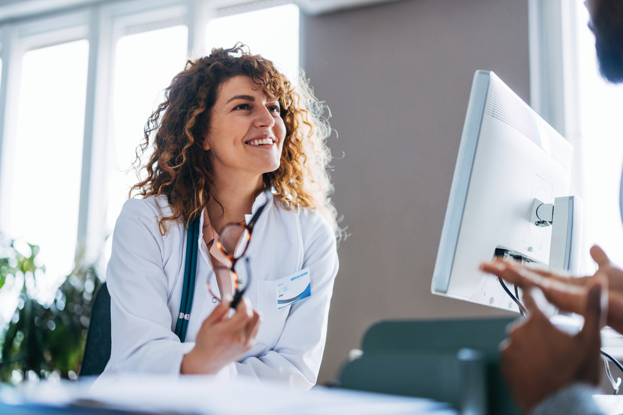 Friendly Female Doctor Smiling During a Consultation in a Bright Office Setting