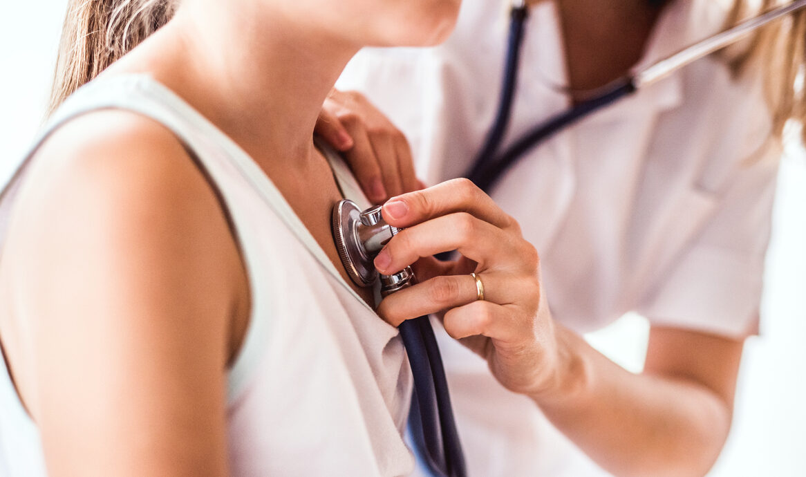 Young female doctor examining a small girl in her office.