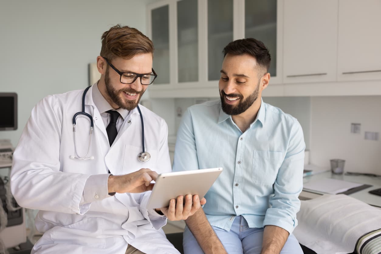 Doctor reviewing medical information on a tablet with a patient during a consultation at a healthcare clinic