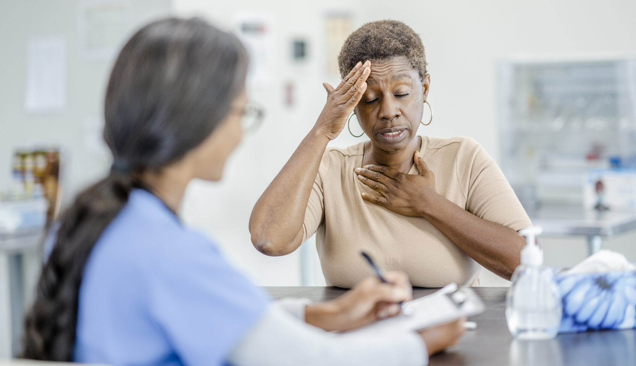 Female medical professional meeting with an African American patient in her 60's to discuss some health concerns.