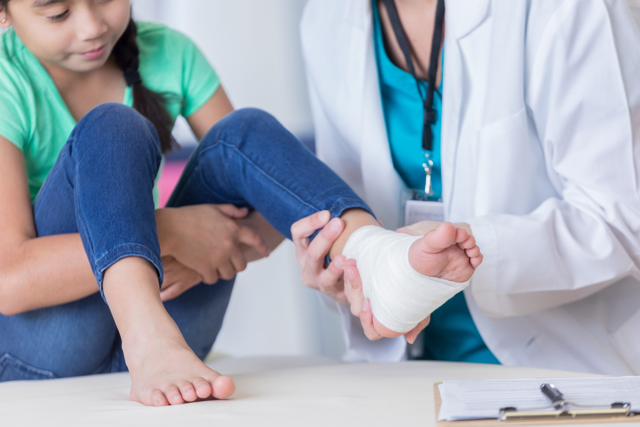 Doctor examines young girl's injured ankle