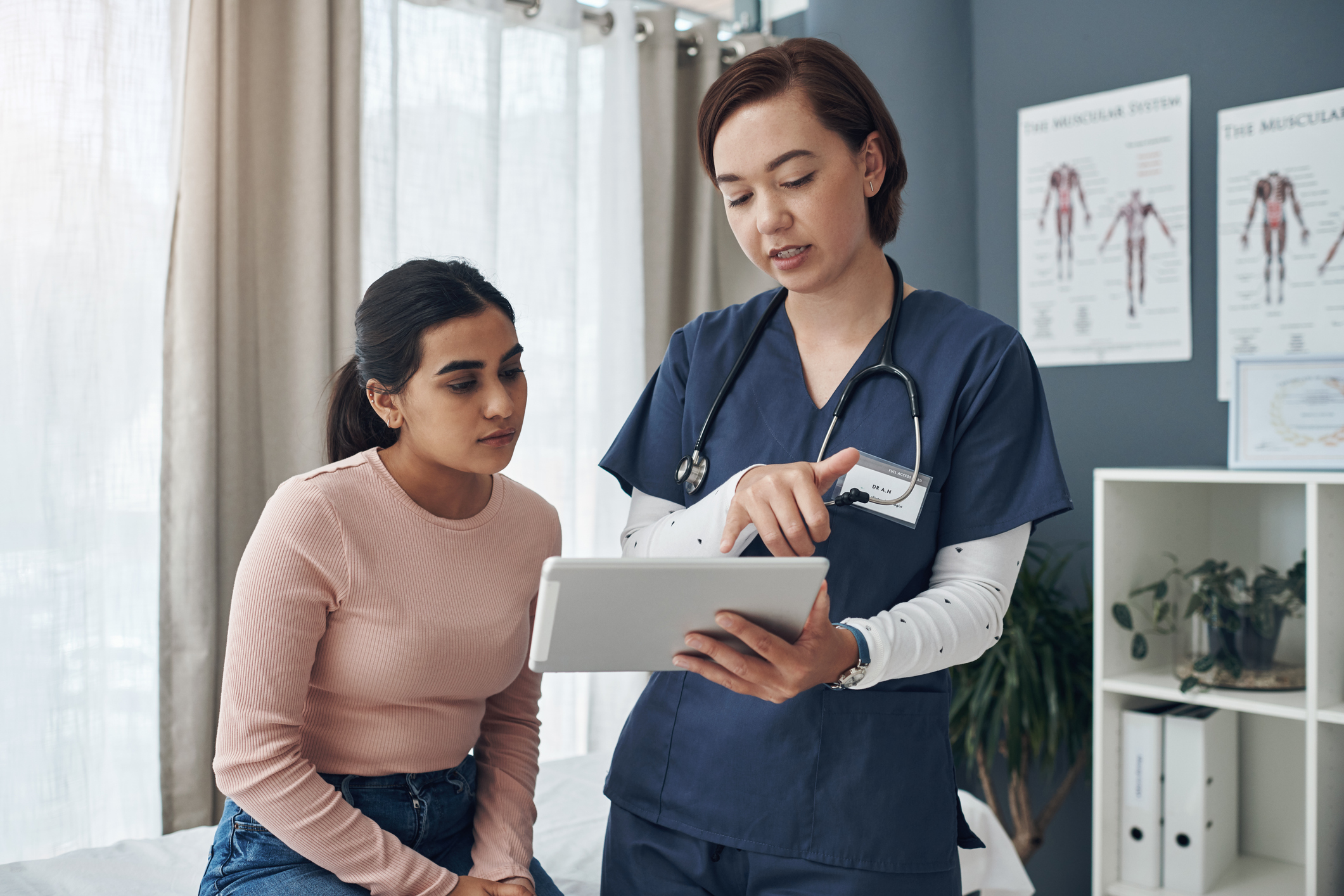 Shot of a young female doctor talking to a patient in an office