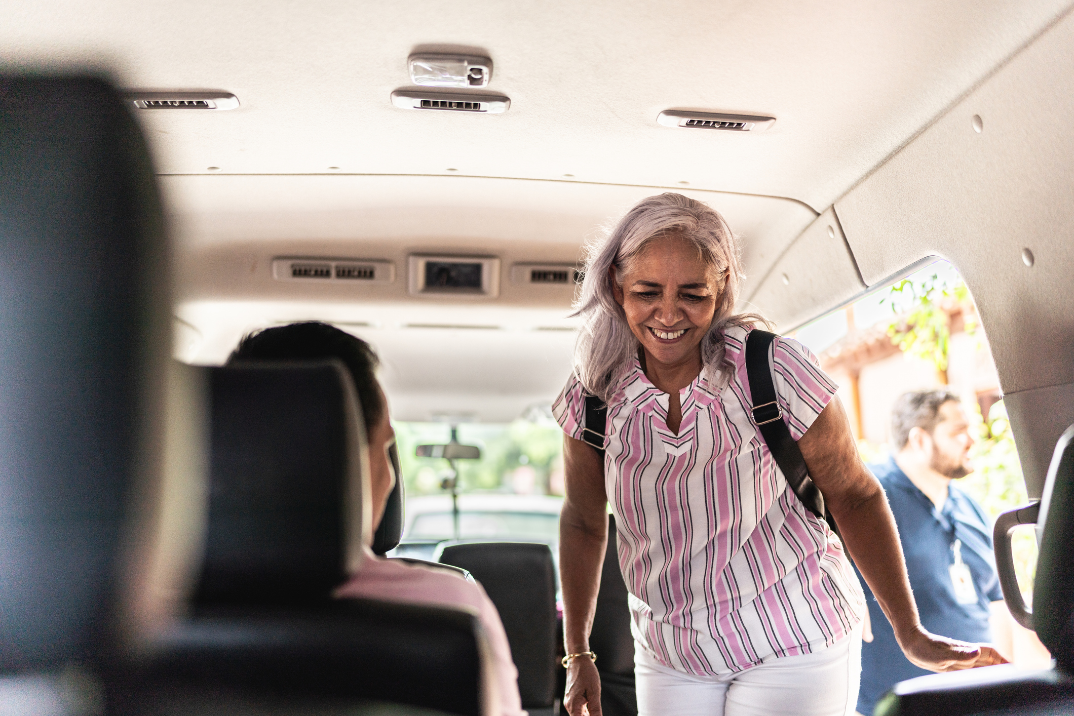 Senior tourist woman getting into a tour van
